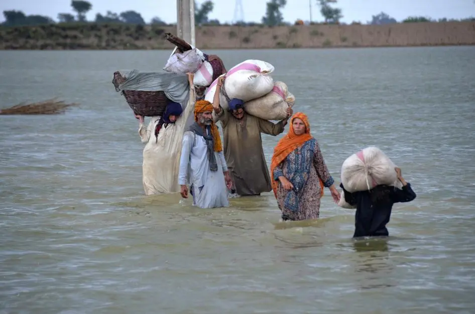 Picture of a family leaving their home to escape flood
